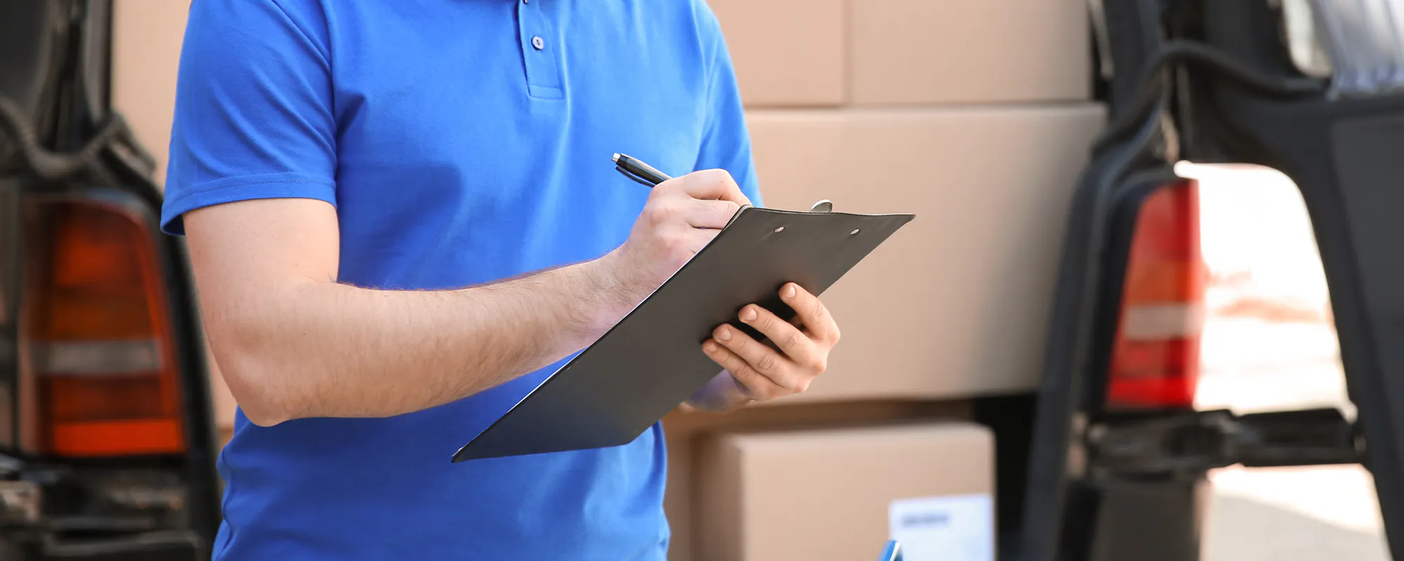 Freelance delivery driver examining his routes on a clipboard; The Risk of Hiring Unlicensed Contractors concept image