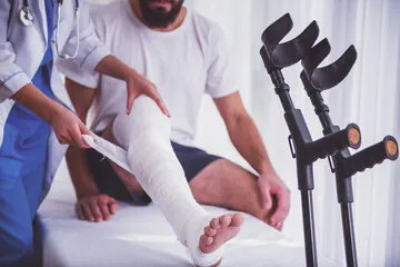 man with broken leg and crutches