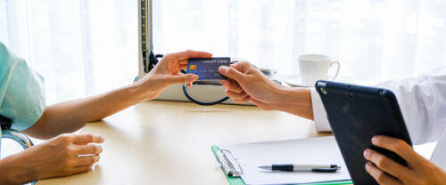 person giving doctor their credit card
