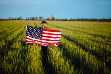 person in field holding american flag