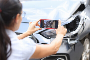 woman taking a picture of a car accident