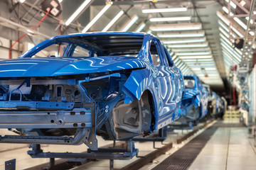 cars on conveyor belt at manufacturer