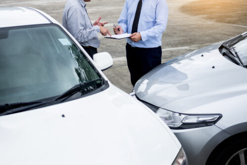 insurance adjuster and man at car accident